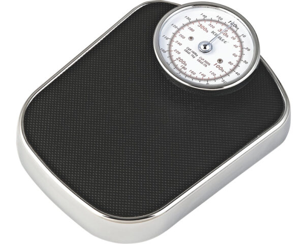 A round analog weighing scale with a black platform and a chrome frame. The scale has a dial with markings in kilograms and pounds. The dial reads "100" in both kilograms and pounds.