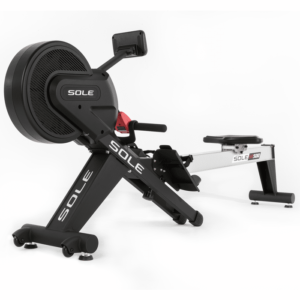 A black and silver SOLE SR500 rowing machine. It has a large flywheel, adjustable seat, and handles for rowing. The machine also features a digital display and a magnetic resistance system.