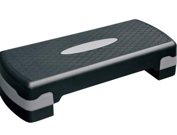 A black aerobic stepper with a gray platform on top. The stepper has a rectangular shape with rounded corners and a textured surface for grip.