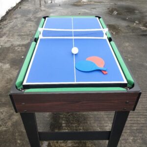 A multi-game table with a blue table tennis surface, a net, and a red paddle. The table also has a green surface underneath, likely for another game like pool.